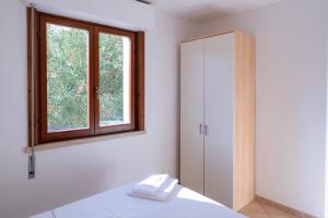 マリーナ・ディ・グロッセートにあるLa Vecchia Posta - B&B e Appartamentiのベッドルーム1室(窓、ベッド1台付)、キャビネットが備わります。