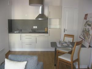 a kitchen with a table and a dining room at Domitys Le Parc Balsan in Châteauroux