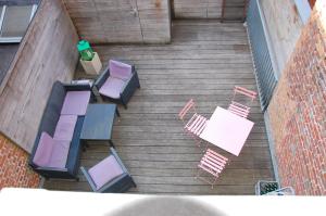 Iconique bv Appartement in hartje Ieper في إبير: إطلالة علوية على الكراسي والطاولات على سطح خشبي