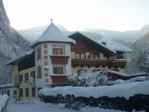 a large building with snow on the ground at Pension Hirlatz in Hallstatt