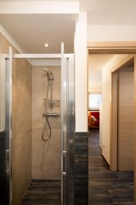 een inloopdouche in een badkamer met een glazen deur bij Appartamento Dragorosa Livigno in Livigno
