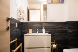 een badkamer met een wastafel en een spiegel bij Appartamento Dragorosa Livigno in Livigno