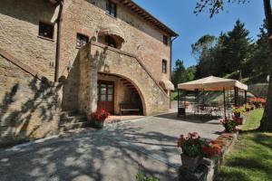 a large brick building with a table and a tent at Azienda Agricola e Agriturismo Vallorsi in Terricciola