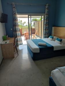 a bedroom with two beds and a sliding glass door at MARINA , 2mn à PIEDS PLAGE BOUCAN CANOT in Saint-Gilles les Bains