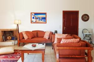 ein Wohnzimmer mit einem Sofa und einem Tisch in der Unterkunft Villa Sunset with stunning sea view, kids area and hammocks on roof terrace in Agia Triada