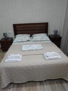 um quarto com uma cama com toalhas em Apartments on Akhalubani St 2 em Tbilisi