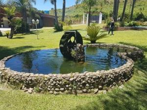 a small pond with a statue in a garden at Casarão Biazolli in Farroupilha