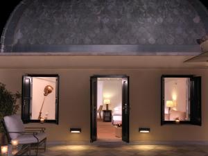 a living room with two mirrors and a chair at Poseidonion Grand Hotel in Spetses