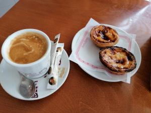 a cup of coffee and two donuts on a table at Vivenda A Nossa Coroa in Coja