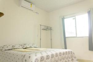 um quarto branco com uma cama e uma janela em Linda Casa c Wi-Fi a 900m da Praia de Itatinga MA em Alcântara