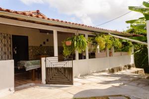 um alpendre de uma casa com um portão e plantas em Linda Casa c Wi-Fi a 900m da Praia de Itatinga MA em Alcântara