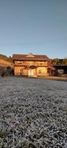 a house with a field of fish in front of it at Casarão Biazolli in Farroupilha