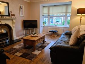 a living room with a couch and a coffee table at Spacious 4 bed home in a quiet cul-de-sac in Coundon