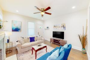 uma sala de estar com um sofá e uma televisão em East Hill Vibes em Pensacola