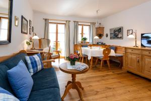 ein Wohnzimmer mit einem blauen Sofa und einem Tisch in der Unterkunft Landhaus Hubertus in Bad Tölz