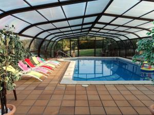una casa junto a la piscina con techo de cristal y sillas alrededor en Señorio De Altamira - Adults Only, en Santillana del Mar