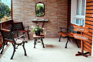 a patio with two benches and a table with flowers at Casarão Biazolli in Farroupilha
