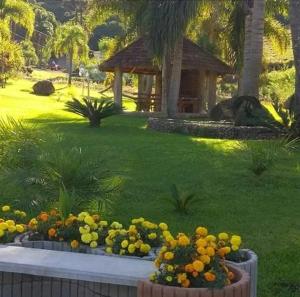 a garden with flowers in front of a gazebo at Casarão Biazolli in Farroupilha