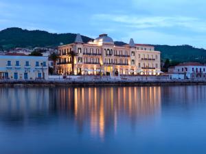 a large building sitting next to a body of water at Poseidonion Grand Hotel in Spetses
