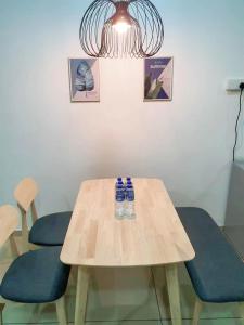a wooden table with two blue chairs and a light fixture at Condo @ Bukit Indah/ Legoland/ Eco Botanic 6 pax in Gelang Patah