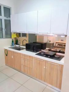 a kitchen with a sink and a microwave at Condo @ Bukit Indah/ Legoland/ Eco Botanic 6 pax in Gelang Patah