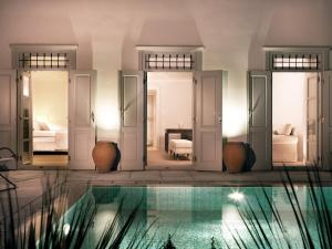 a villa with a swimming pool and a bedroom at Poseidonion Grand Hotel in Spetses