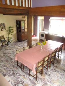 ein Esszimmer mit einem rosa Tisch und Stühlen in der Unterkunft Maison spacieuse au cœur de Queyssac avec jardin in Queyssac