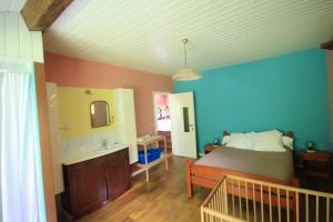 ein Schlafzimmer mit einem Bett, einem Waschbecken und einem Spiegel in der Unterkunft Maison spacieuse au cœur de Queyssac avec jardin in Queyssac + 5 Fotos