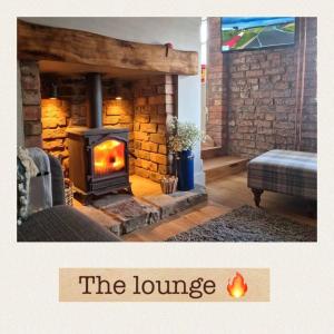 a living room with a fireplace and a couch at Stunning quirky 2-Bed Cottage in New Brighton in Wallasey