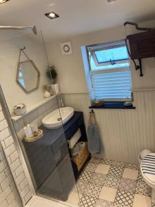 a bathroom with a sink and a toilet and a window at Stunning quirky 2-Bed Cottage in New Brighton in Wallasey