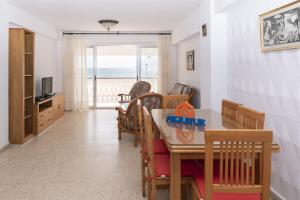 a living room with a table and chairs and a television at Lider, 2-G in Cullera