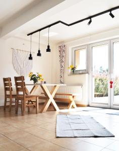 a dining room with a table and chairs and windows at Pokoje Gościnne UAnny in Nowy Targ