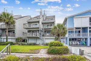 a building with palm trees in front of it at Pelican Pointe 2C in Clearwater Beach