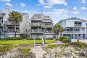 a row of houses on the beach with palm trees at Pelican Pointe 2C in Clearwater Beach