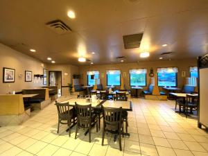 a dining room with tables and chairs in a restaurant at Beaverlodge Motor Inn in Beaverlodge