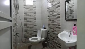łazienka z toaletą i umywalką w obiekcie Ainaz Homestay Balik Pulau w mieście Balik Pulau
