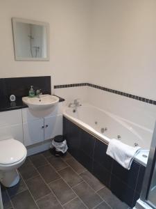 een badkamer met een wastafel, een bad en een toilet bij Spacious fully furnished 2 bed appartment next to BAE, in Barrow in Furness