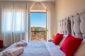 Residenza Dalia&Lea في فيرونا: غرفة نوم بسرير ومخدات حمراء ونافذة
