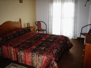 a bedroom with a bed and two chairs and a window at Hotel Rural El Cuco in Ribatajadilla