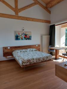 La casa di Maia - Alloggio Agrituristico في بيدافينا: غرفة نوم بسرير وطاولة وكراسي