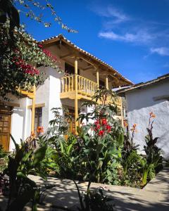 ein Haus mit einer Terrasse und Blumen davor in der Unterkunft El Albergue Ollantaytambo in Ollantaytambo
