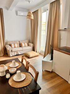 ein Wohnzimmer mit einem Tisch, Stühlen und einem Sofa in der Unterkunft ADI BOUTIQUE HOUSE in Thessaloniki