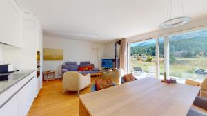 a kitchen and living room with a large window at Abitaziun Bellaval 1A - Celerina in Celerina