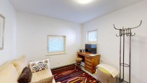 a living room with a couch and a desk at Abitaziun La Dmura 12 - Samedan in Samedan