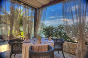a dining room with a table and a large window at Hotel Forza Mare in Kotor