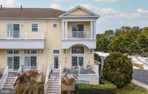 a large yellow house with a white balcony at Relaxing Bethany Beach Retreat, Pools, Families Welcome Including Dogs! in Ocean View