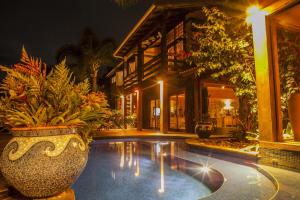a resort with a pool with plants and a building at Solar Mirador Exclusive Resort e SPA in Praia do Rosa