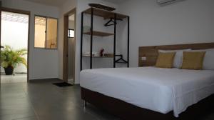 D'Rio Aparta estudios في ريوهاتشا: غرفة نوم بسرير ابيض كبير مع مخدات صفراء