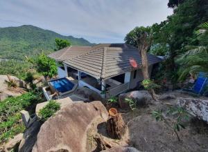 a house with a roof on top of some rocks at Ocean View Villa in Ko Tao