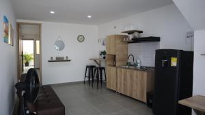 里奧阿查的住宿－D'Rio Aparta estudios，厨房配有黑色冰箱和台面